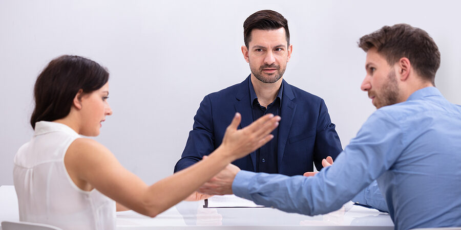 young couple arguing with each other in front of judge at courtroom