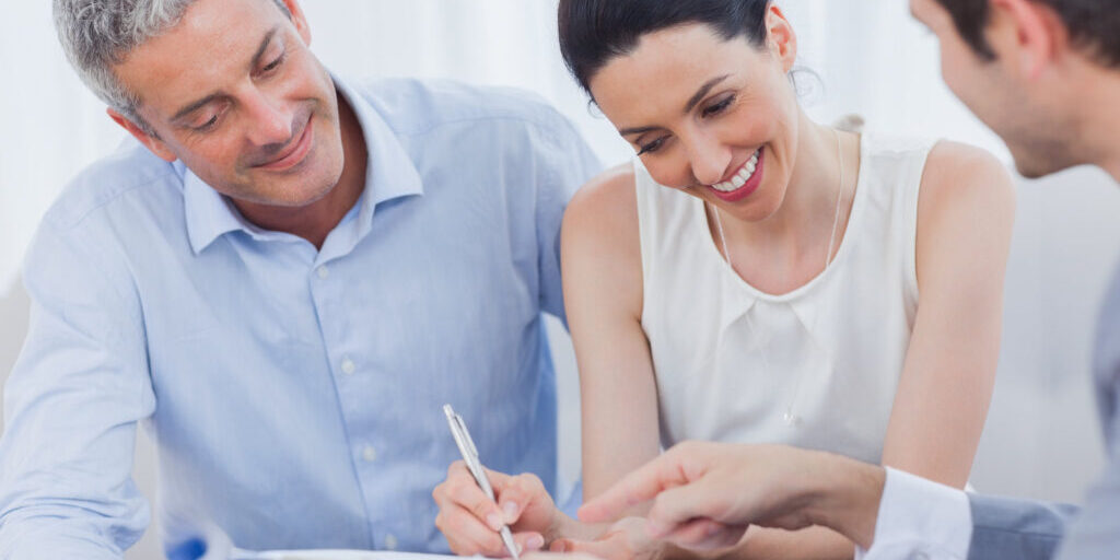 smiling woman sign on a contract with her partnership on sofa at office