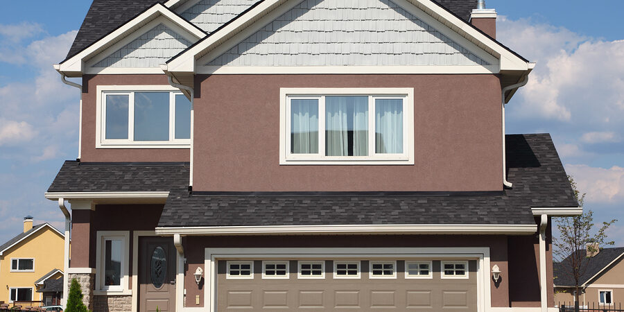 new two-storied white-brown brick cottage with beige garage and white roof.